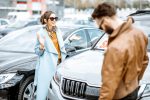 Man and woman choosing car to buy outdoors